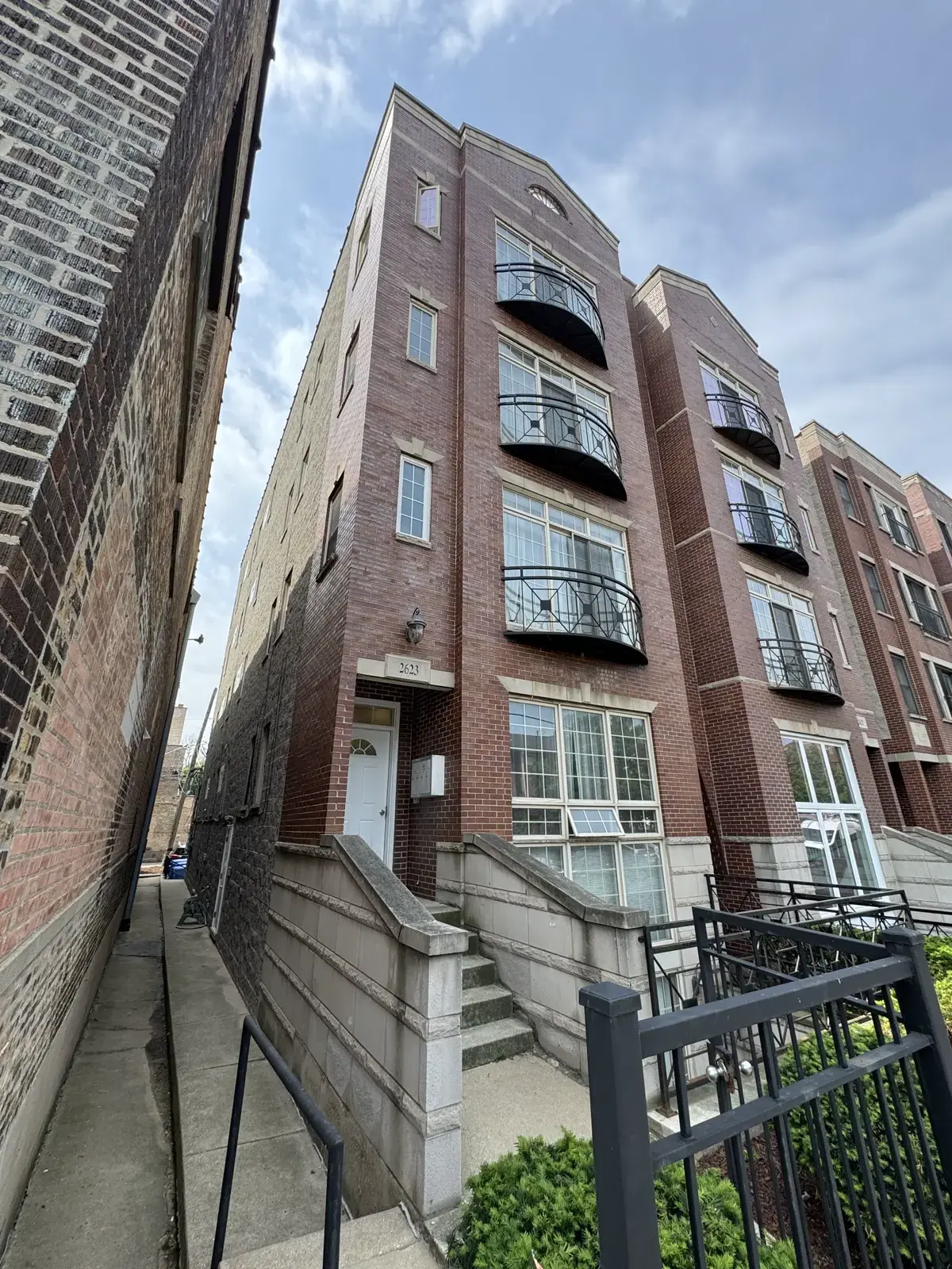 Chicago multi-story brick and stone building facade with arched windows, viewed from a low angle against a blue sky