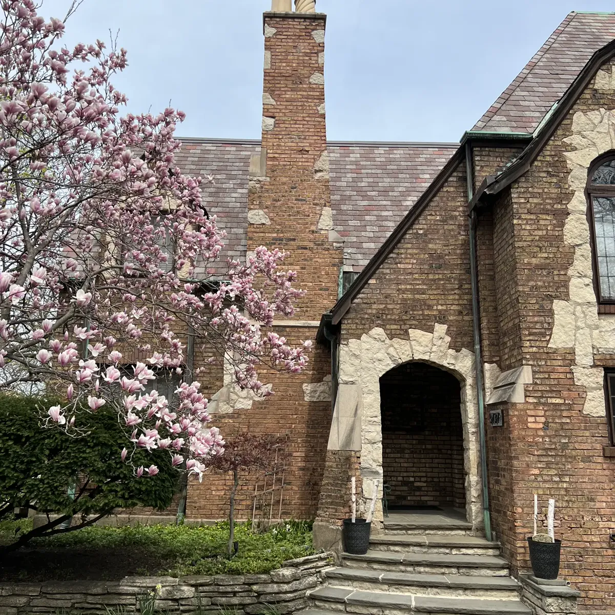 Red-brick residential chimney with visible tuckpointing and patch repair