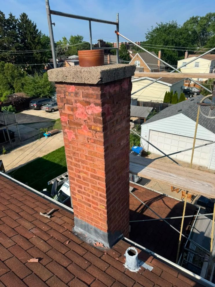 Chimney before reconstruction with damaged brickwork and an older concrete cap