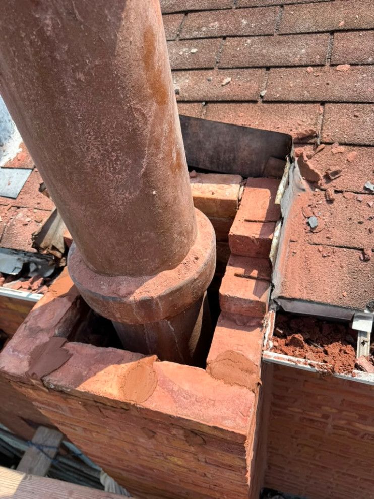 Open chimney structure showing damaged masonry around the clay flue liner