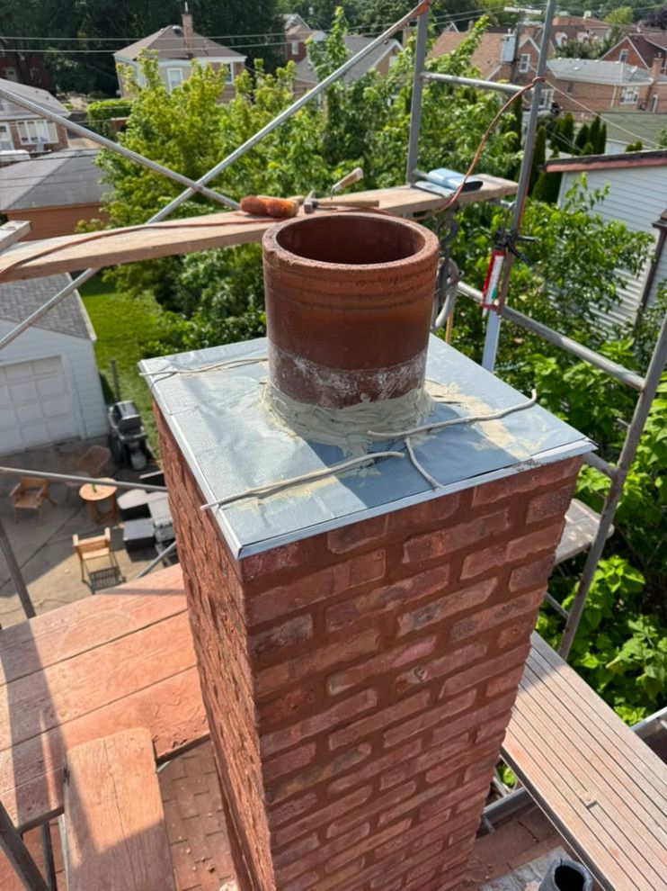 Chimney restoration with completed flashing and rebuilt brickwork