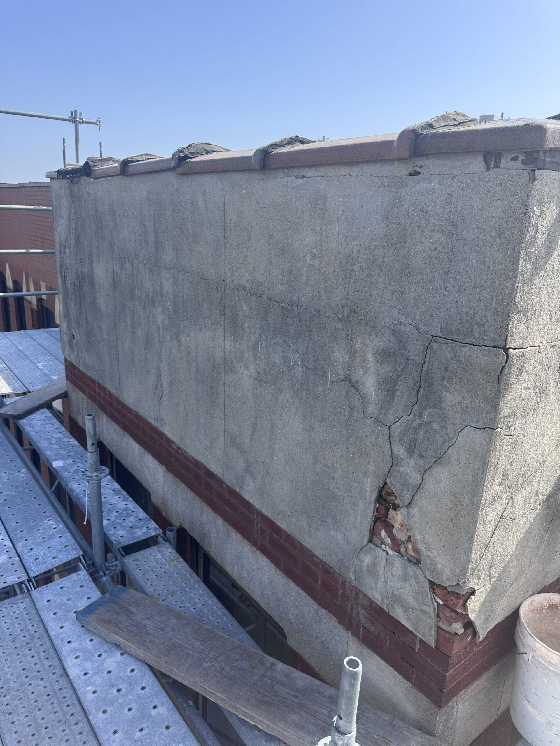 Parapet wall before reconstruction, showing weathered upper-course masonry