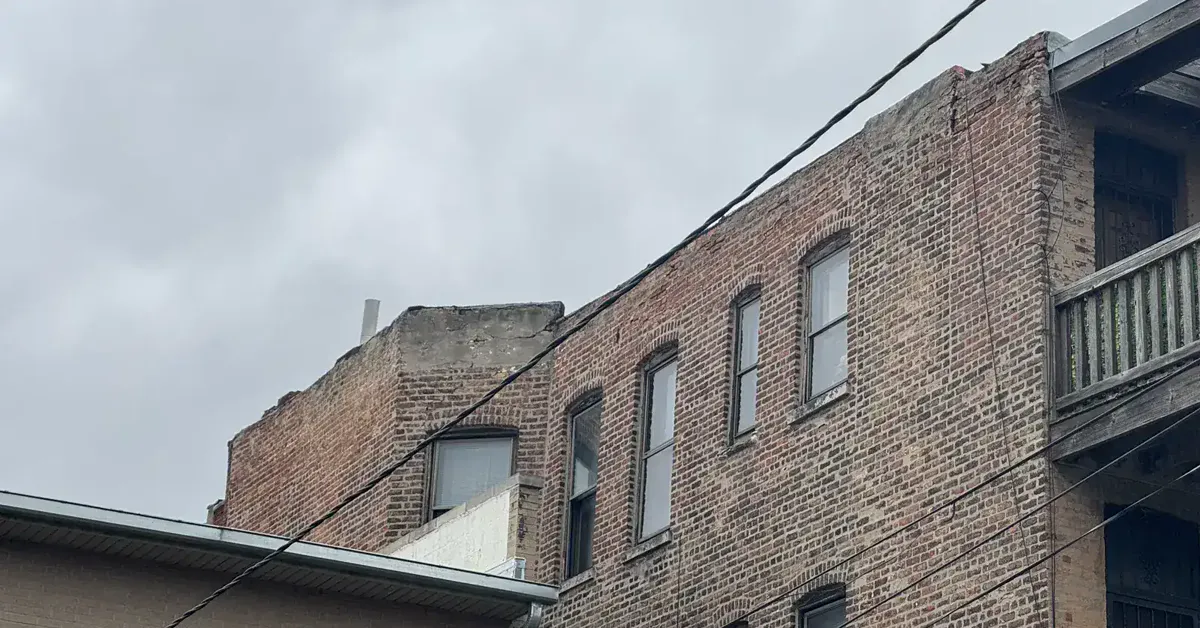 Brick facade with failing parapet wall mortar joints