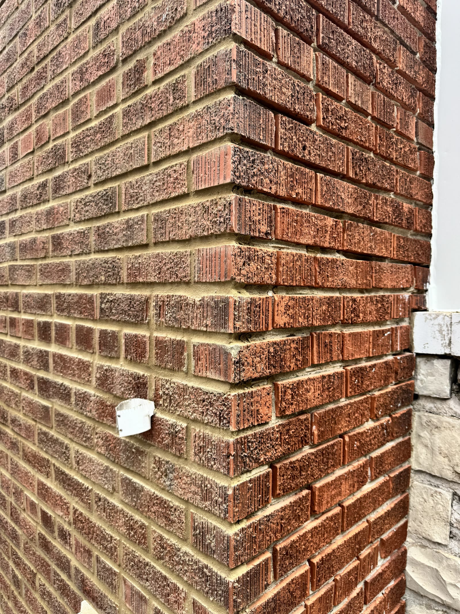 Zoomed-out view of a brick wall corner showing the masonry and mortar joints