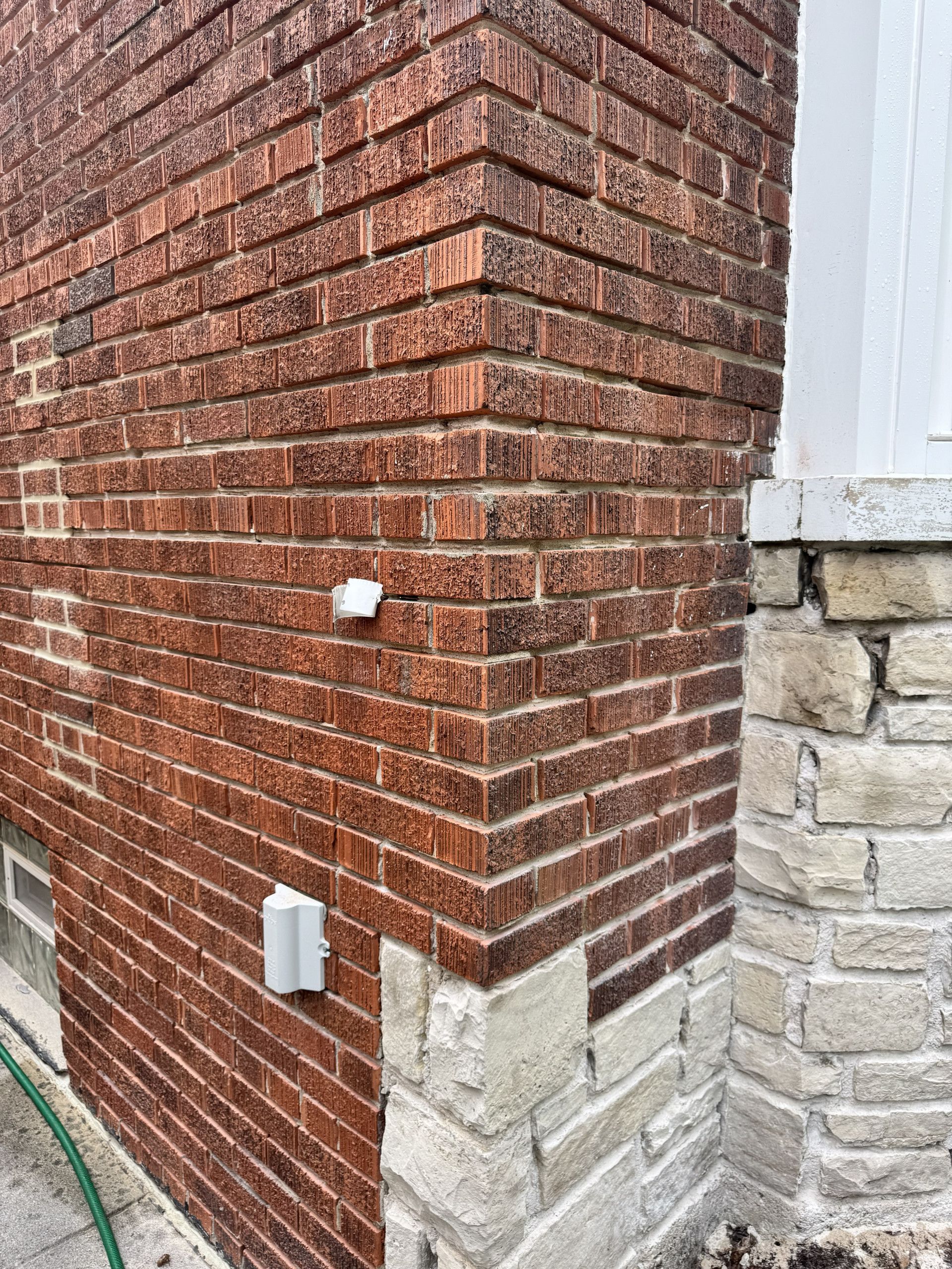 Weathered mortar joints at a brick corner before masonry restoration