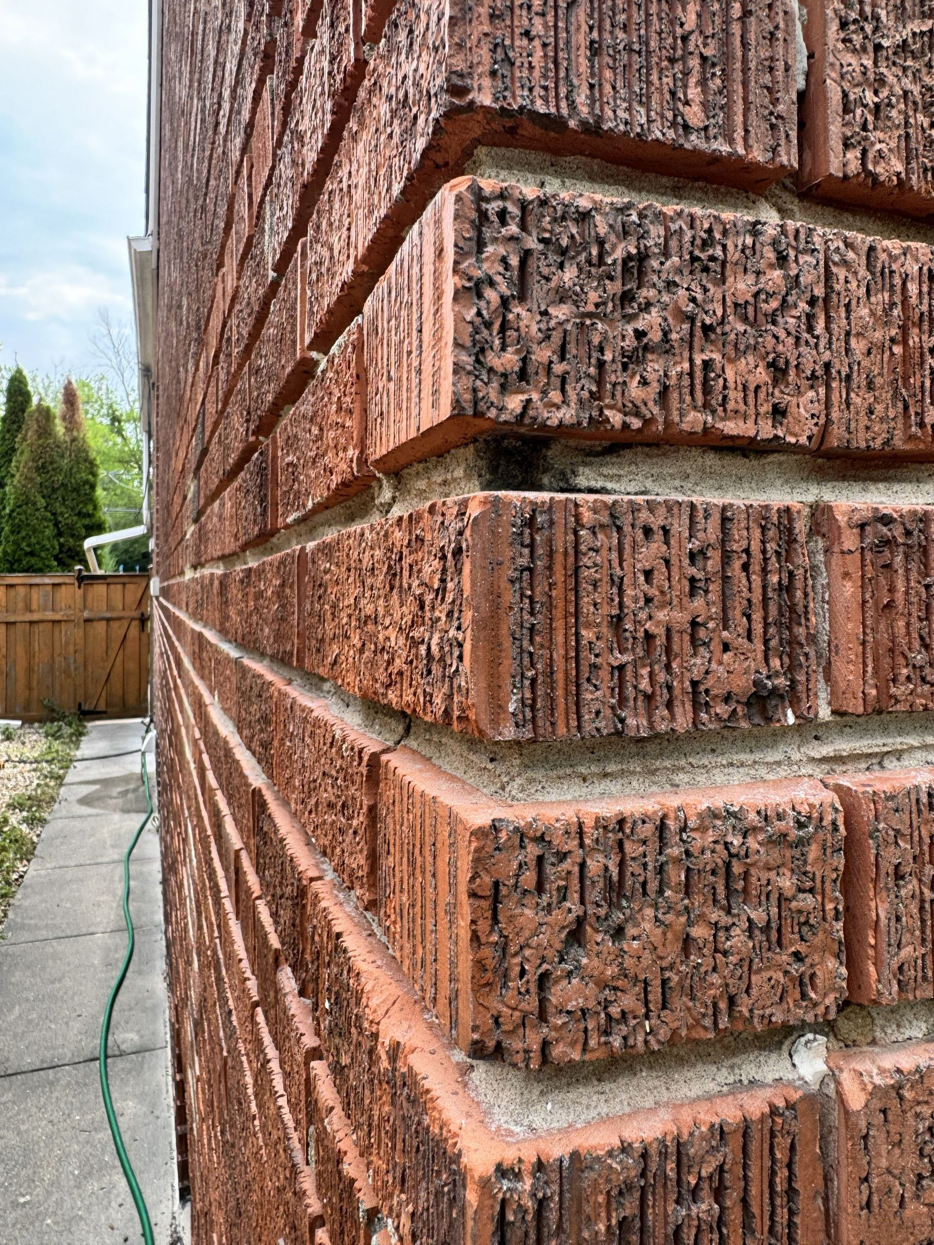 Close view of worn mortar and brick texture along the exterior wall