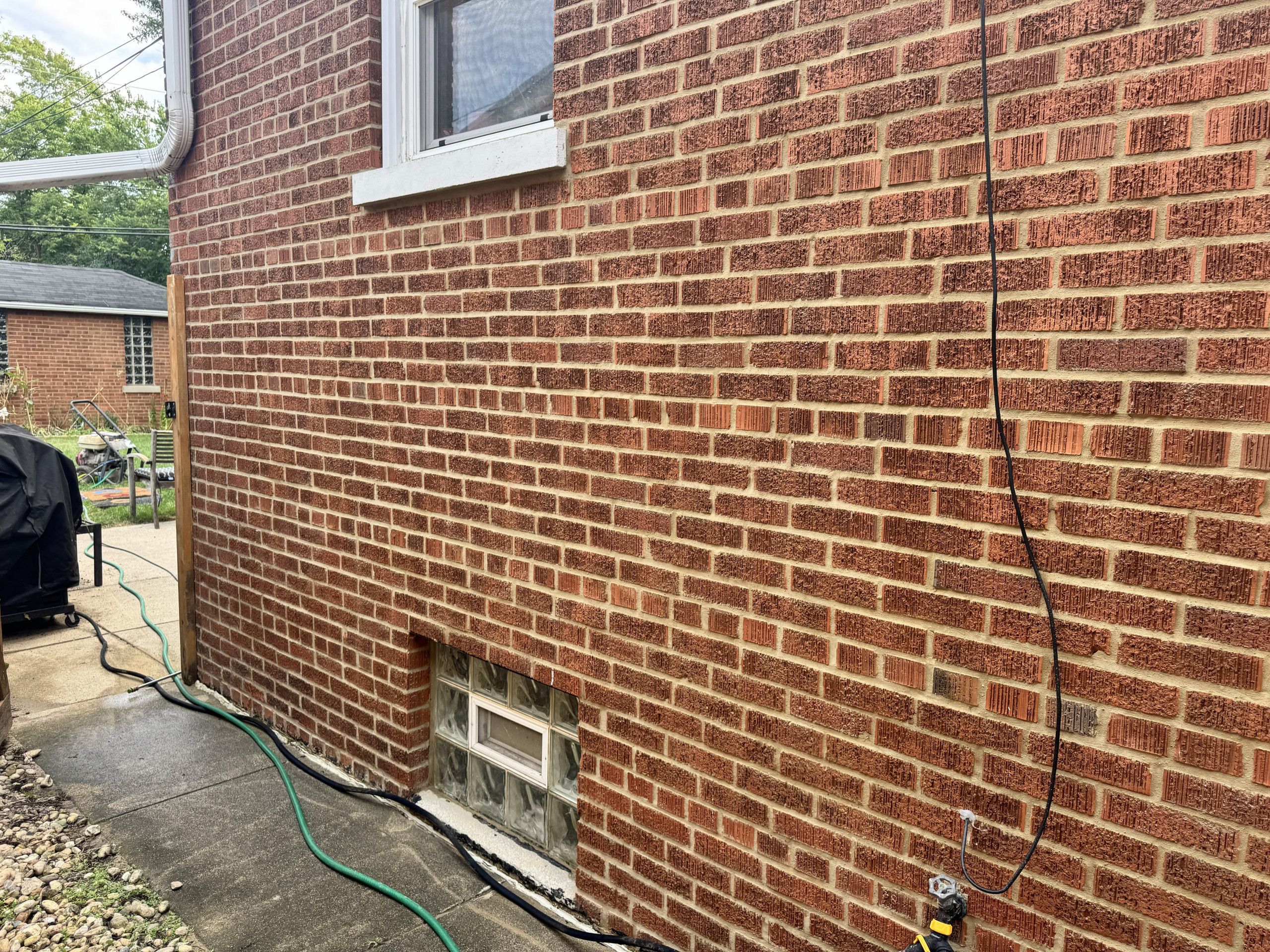 Exterior side elevation before tuckpointing, with worn mortar across the brickwork