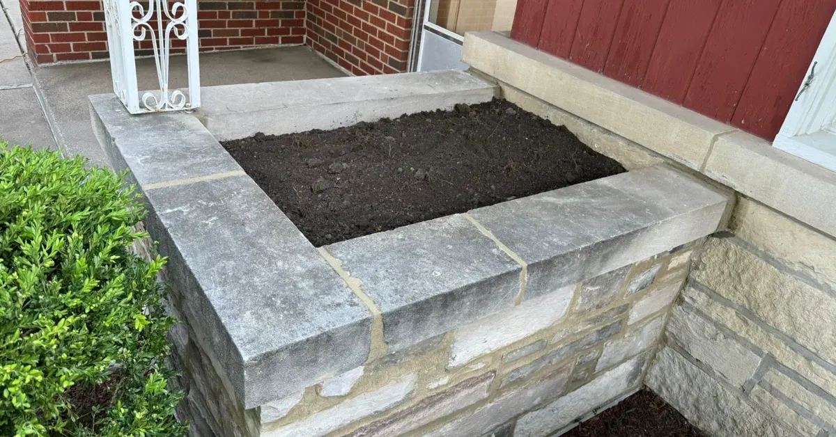 Completed wingwall rebuild with matching brick, clean mortar joints, and a fresh limestone cap stone
