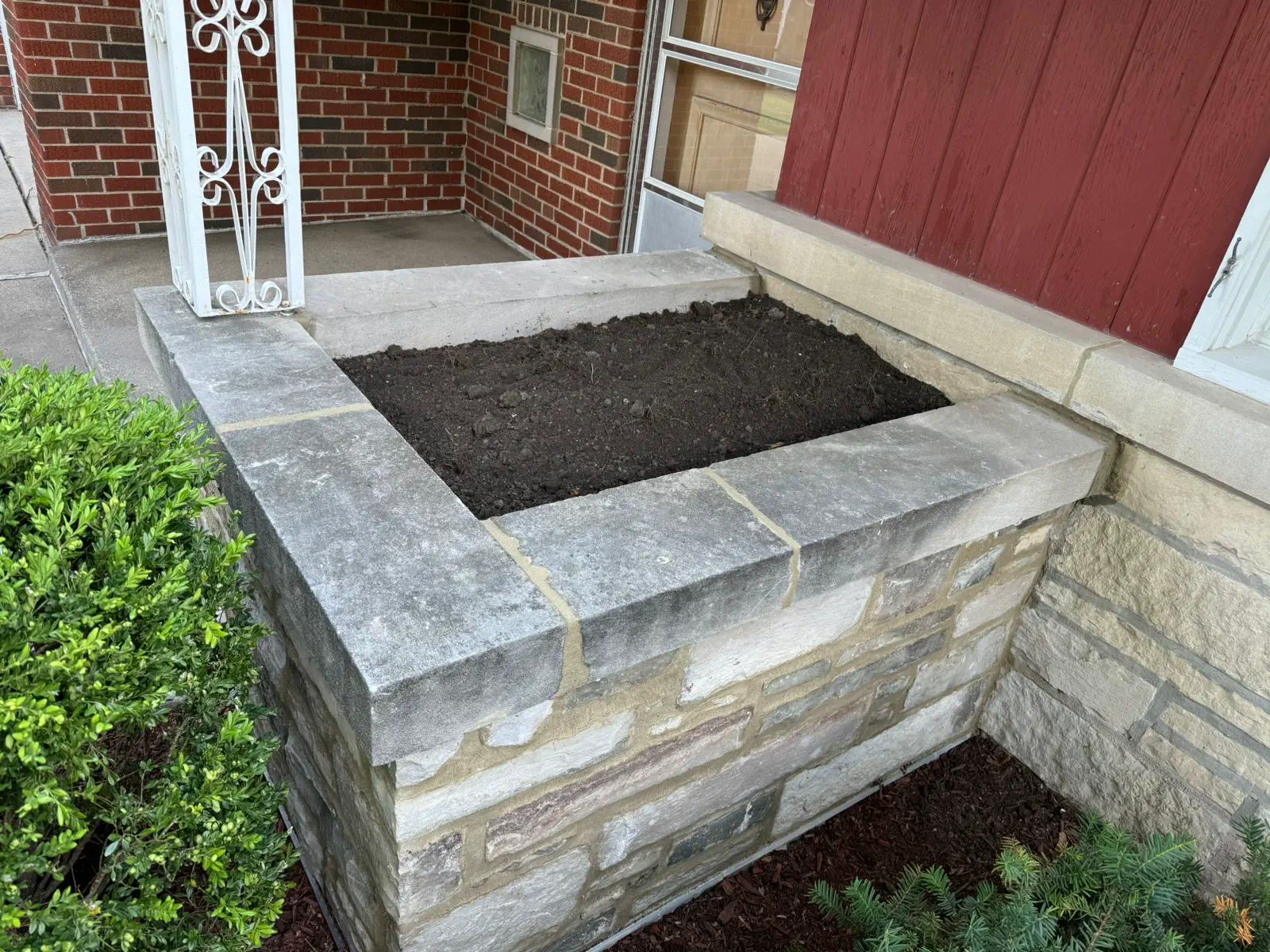 Completed wingwall rebuild with matching brick, clean mortar joints, and a fresh limestone cap stone